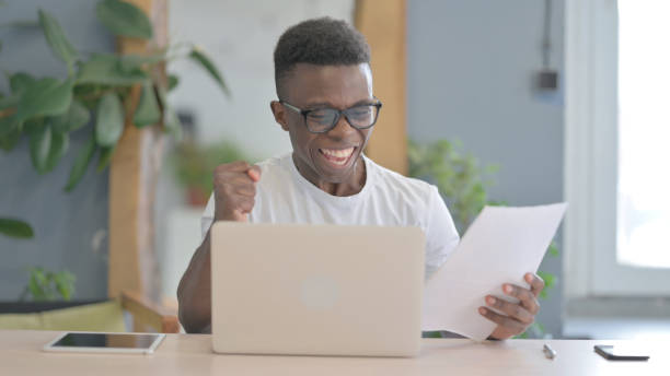 istock African Man Celebrating Successful Contract in Office 1470540951