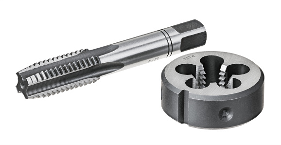 Close-up of two sharp steel tools for tapping and threading in metal materials. Metalworking instruments in engineering industry