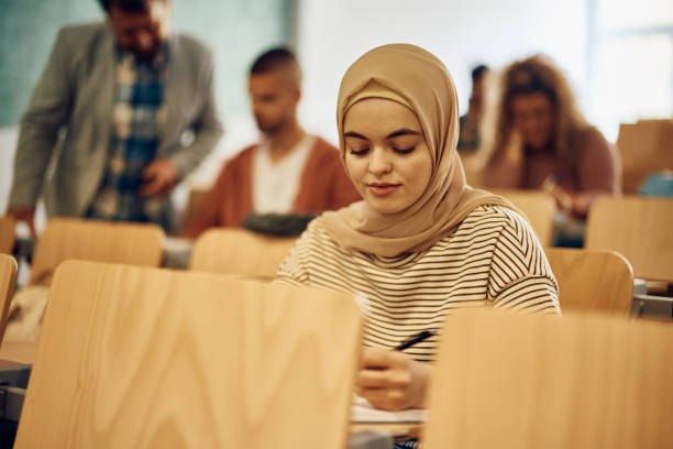 istock Female Muslim student writing an exam at the university. 1470543844