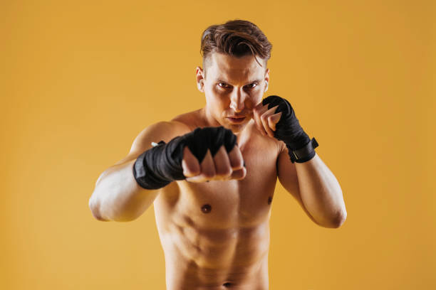 Athletic man with fit muscular body training in studio stock photo