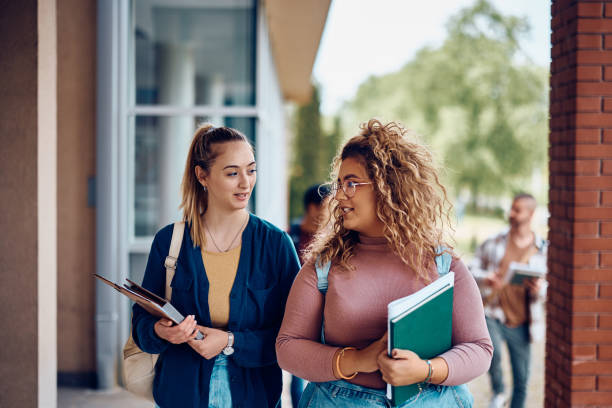 istock Female college friends talking while going on a lecture at campus. 1470544040