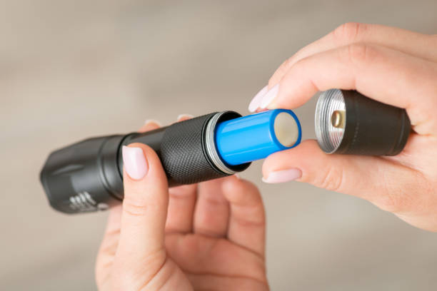 istock Flashlight with 18650 battery in female hands, close up 1470545292
