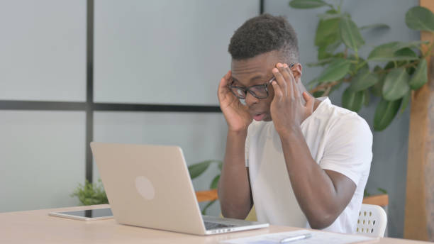 istock Young African Man with Headache Working on Laptop 1470546021