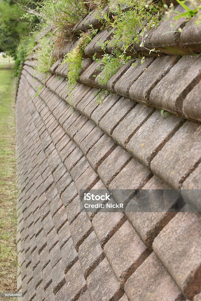 Retaining Wall A layered stone retaining wall in a park Grass Stock Photo