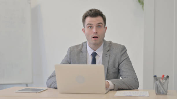 istock Young Businessman Shocked While Working on Laptop 1470554125
