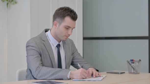 istock Young Businessman Working on Documents and Calculating Business Data 1470555974