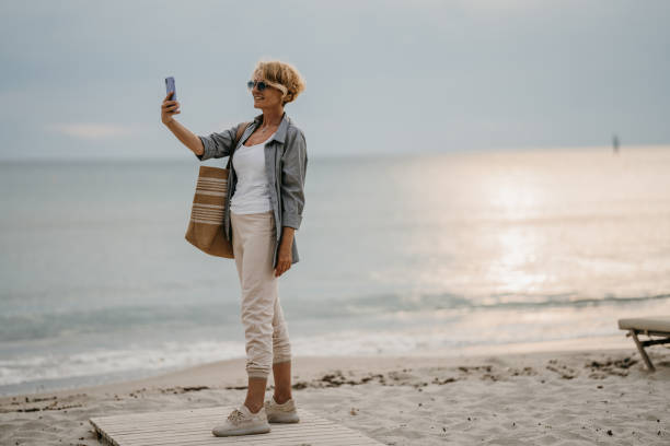 istock Woman taking a selfie by the sea 1470556038