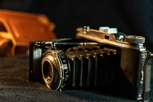 Old SLR film camera and a lens on black background, Photography Concept.