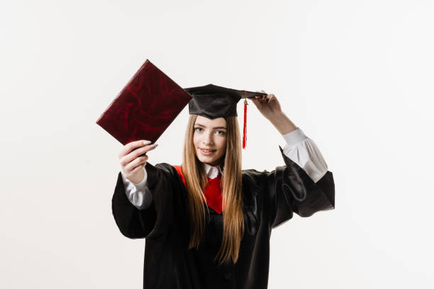 istock Confident student with diploma in graduation robe and cap ready to finish college. Future leader of science. Academician young woman in black gown smiling. 1470556339