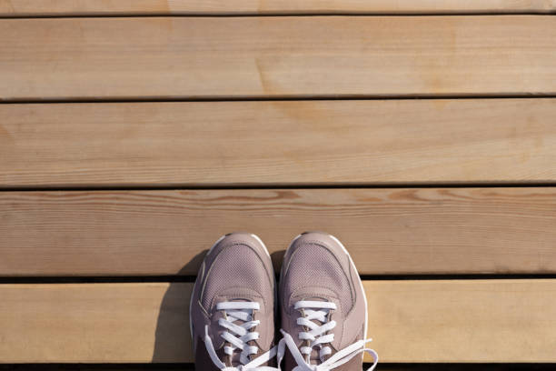 istock sneakers stand on wooden planks. Place for text 1470557618