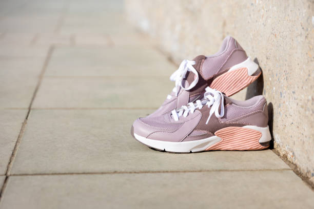 istock sneakers stand on paving stones. Place for text 1470557626