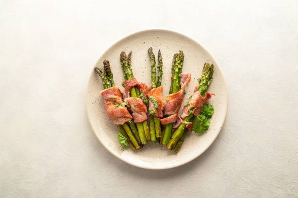 istock Wrapped asparagus with bacon in a plate. Top view 1470558015