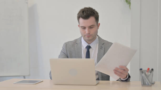 istock Young Businessman Working on Laptop and Documents 1470559789