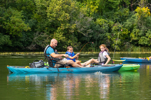 Family kayak trip. An elderly married couple rowing a boat on the river, a water hike, a summer adventure. Age-related sports, mental youth and health, tourism, active old age