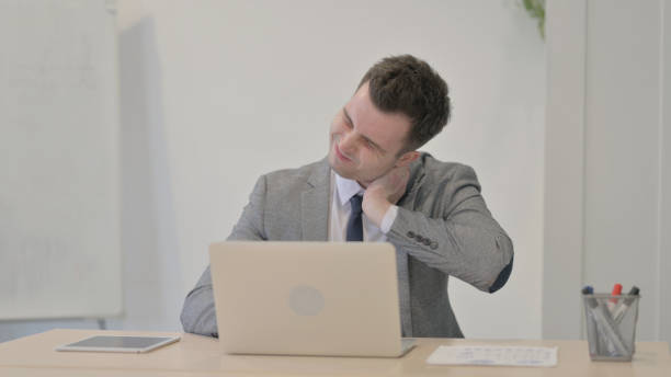 istock Young Businessman having Neck Pain while using Laptop 1470560681