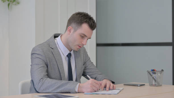 istock Young Businessman Working on Documents in Office 1470561450