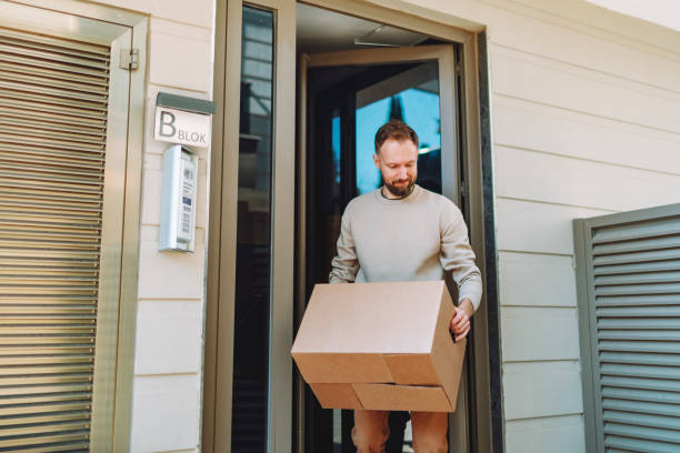 istock Man receiving parcel in cardboard box at front door 1470566582