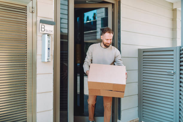 istock Man receiving parcel in cardboard box at front door 1470566601