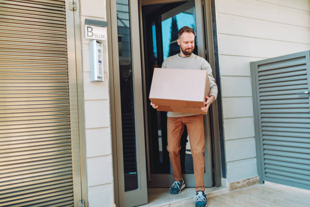 istock Man receiving parcel in cardboard box at front door 1470566701
