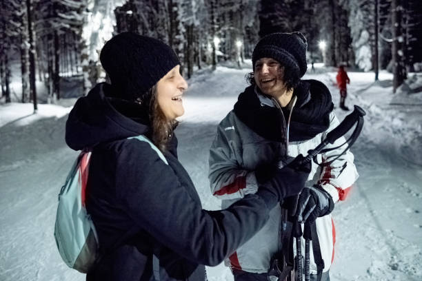 istock Two women talking on a lighted ski slope at night. 1470567728