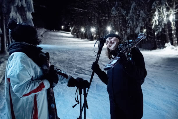istock Two women talking on a lighted ski slope at night. 1470567769