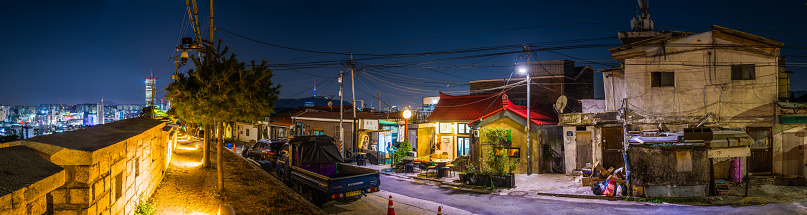 Namsan Tower overlooking the quiet night streets of Iowa Mural Village in central Seoul, South Korea.