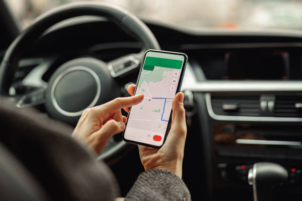 istock Closeup of female traveler using cell phone with gps navigation app on screen while sitting in car 1470569782