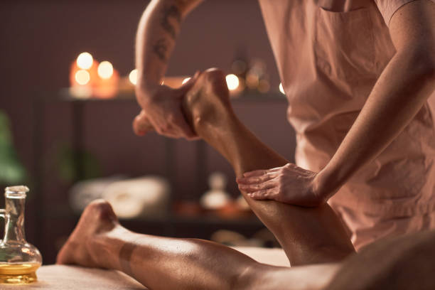 Leg Massage for Fatigue Release Spa therapist massaging legs of client to release fatigue woman pushing tire stock pictures, royalty-free photos & images