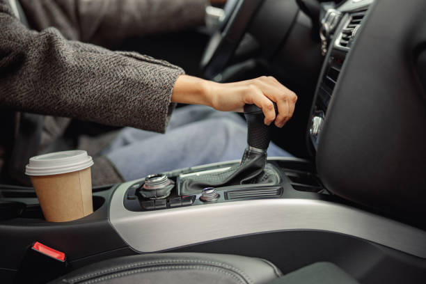 Close up of woman change speed holding hand on gearbox in the car stock photo