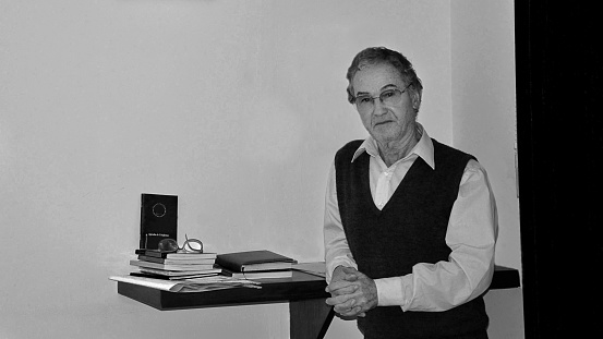 Portrait of a lawyer leaning against the desk in his work office. The photo was taken inside the venue.