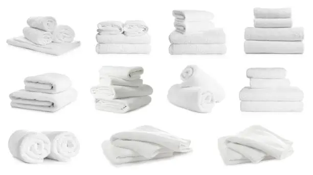 Photo of Set of folded and rolled towels on white background