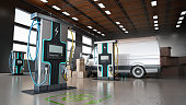 Electric commercial vehicles, industrial charging stations and stack of cargo boxes inside a distribution warehouse