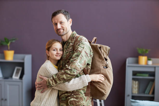 istock Side view man wearing military uniform embracing daughter and looking at camera 1470572549