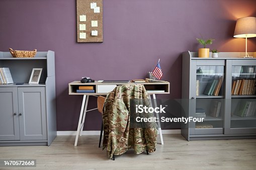 istock Background image of military uniform at desk chair in office with American flag 1470572668