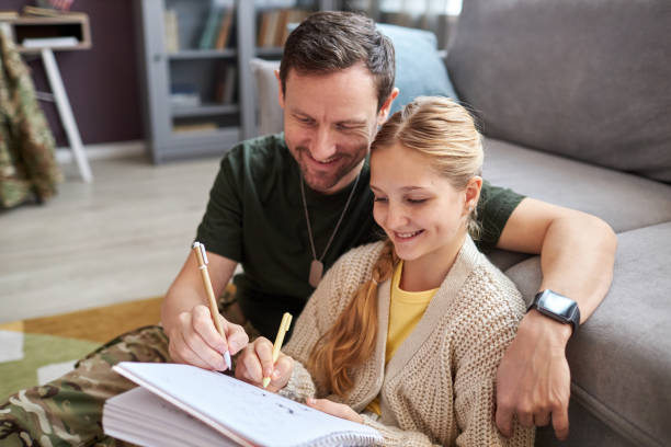 istock Caring military father helping daughter doing homework and smiling happily 1470572736