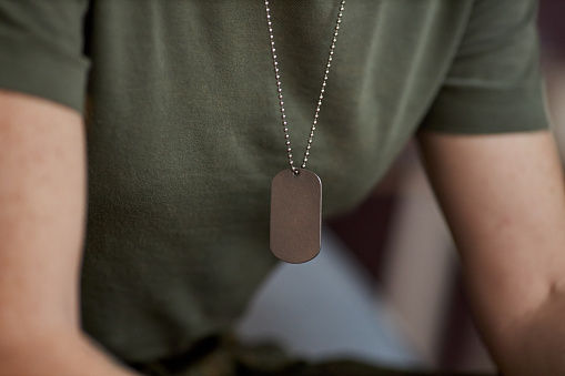 Close up of unrecognizable military woman with focus on tag necklace, copy space