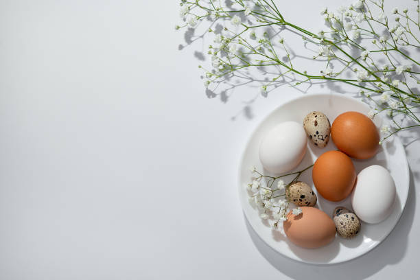 istock Aesthetic minimalist Easter table decoration, eggs and flowers on white plate, on light neutral background. Elegant Scandinavian spring template or banner, copy space 1470573382