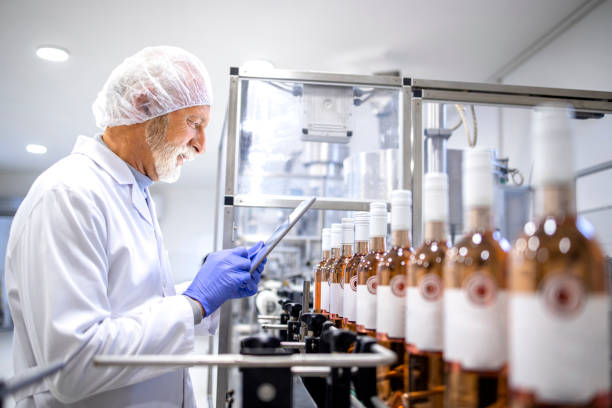 istock Experienced supervisor using digital tablet and controlling process of wine production in alcohol beverage bottling factory. 1470574510