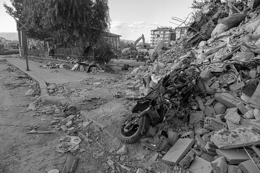 View of a devastated street after the earthquake. a crushed motorcycle. The road is covered with dust.