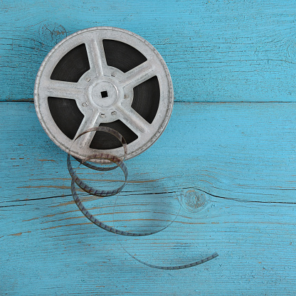 Old film strip on wooden blue background.