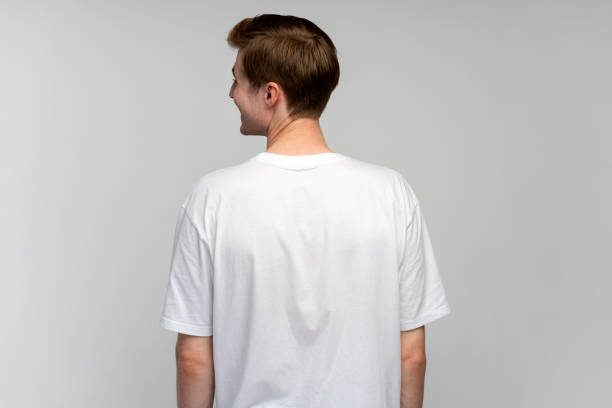 istock Back view of positive man looking away and smiling while posing back to the camera at studio 1470581140