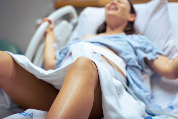 una mujer embarazada en trabajo de parto en el hospital, gritó y empujó al bebé en la sala de partos. parto. - cramping fotografías e imágenes de stock