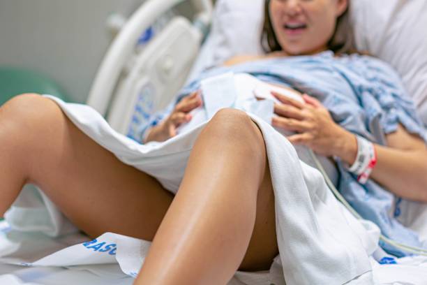 una donna incinta nella sala parto dell'ospedale con contrazioni dolorose, che si prepara per il travaglio. - cramping foto e immagini stock