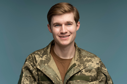 Portrait of young man in t-shirt and camouflage jacket