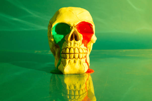Skull with red and green paint leaking from eyes on green background.