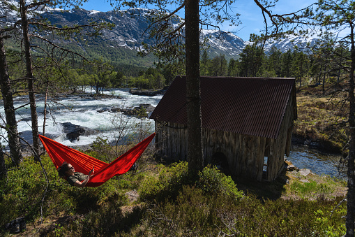 Summer in Norway: adventures in nature outdoor on hammock, by a fjord in Norway