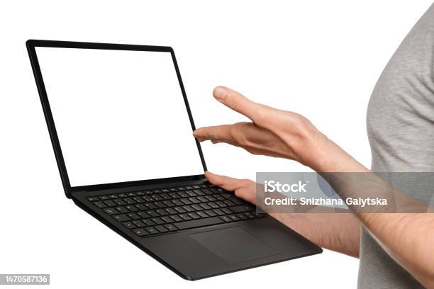 A Man In A Tshirt Holds A Laptop An Ultrabook And Points To The Screen With His Hand Stock Photo - Download Image Now