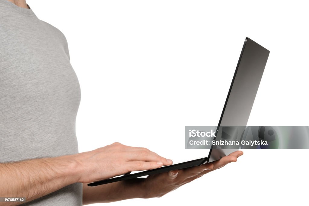 In one hand, a man holds a laptop and the other is typing text on the keyboard. Slim ultrabook in matte black with a touch screen. Adult Stock Photo