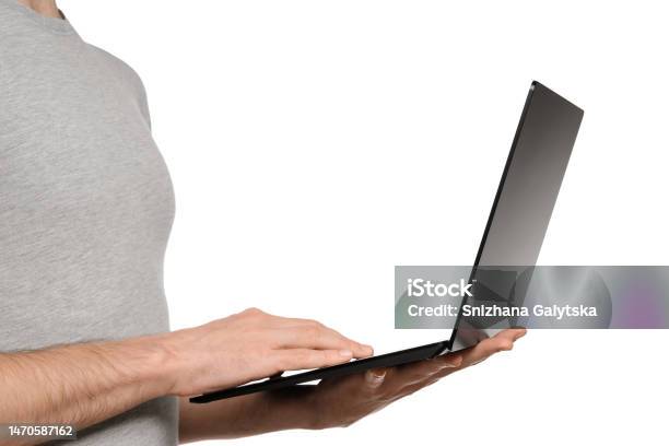 In One Hand A Man Holds A Laptop And The Other Is Typing Text On The Keyboard Slim Ultrabook In Matte Black With A Touch Screen Stock Photo - Download Image Now