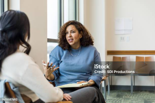 Female Therapist Gestures While Talking With The Unrecognizeable Woman Stock Photo - Download Image Now